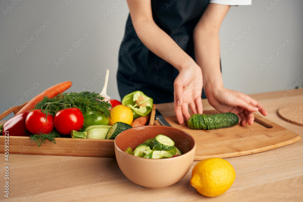 Woman in black apron slicing vegetables kitchen cooking food Woman in black apron slicing vegetables kitchen cooking food
