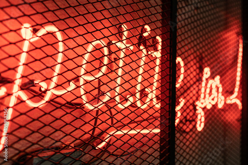 red neon sign behind bars
