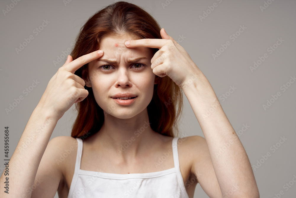 beautiful woman in a white t-shirt pimples on the face isolated background beautiful woman in a white t-shirt pimples on the face isolated background