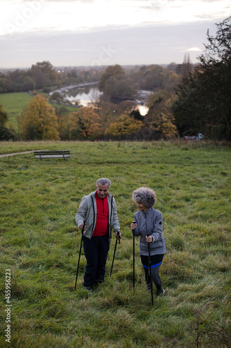 Smiling, affectionate senior couple wih walking sticks