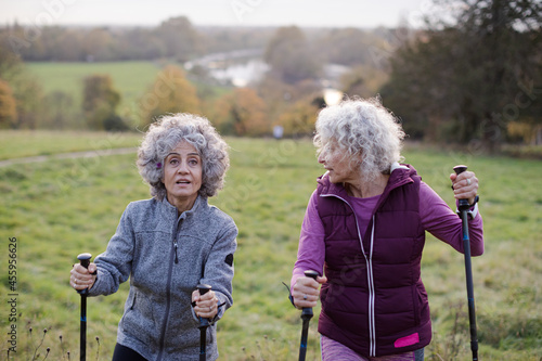 Portrait smiling, happy active senior women friends with walking sticks
