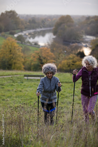 Active senior women friends with walking sticks in autumn park © KOTO