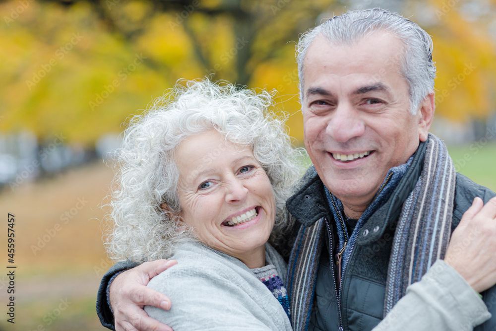 Portrait smiling, affectionate senior couple hugging in park Portrait smiling, affectionate senior couple hugging in park