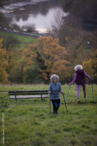 Smiling, affectionate senior women with walking sticks