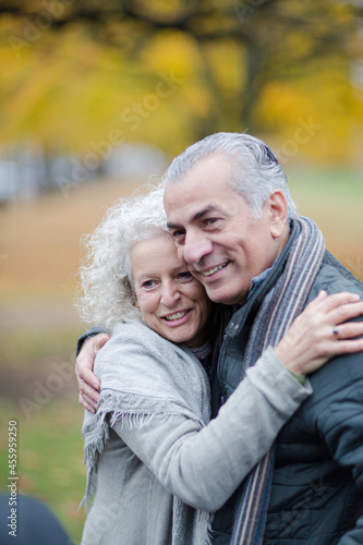 Portrait smiling, affectionate senior couple hugging in park