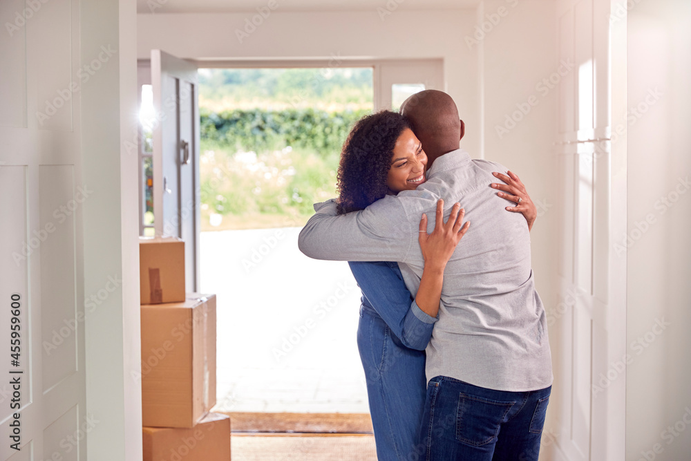 Couple Hugging In Hallway Of New Home On Moving Day Couple Hugging In Hallway Of New Home On Moving Day
