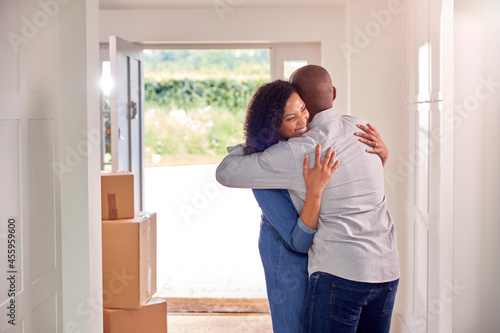 Couple Hugging In Hallway Of New Home On Moving Day