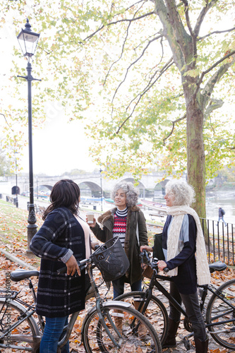 Portrait confident, smiling senior women bike riding in autumn park