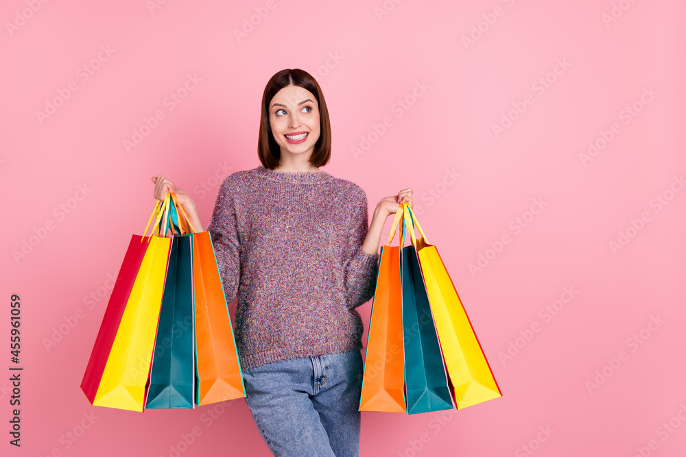 Photo of dreamy cute lady hold many bargains look empty space wear knitted sweater isolated pink color background Photo of dreamy cute lady hold many bargains look empty space wear knitted sweater isolated pink color background