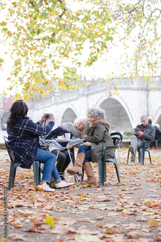 Portrait smiling, happy active senior women friends drinking coffee at autumn park cafe