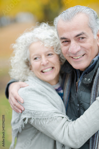 Portrait smiling, affectionate senior couple hugging in park
