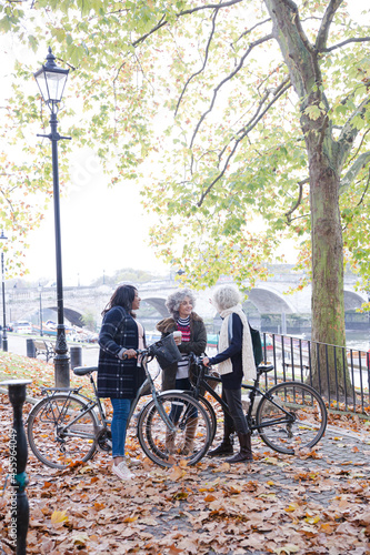 Fototapeta Naklejka Na Ścianę i Meble -  Portrait confident, smiling senior women bike riding in autumn park