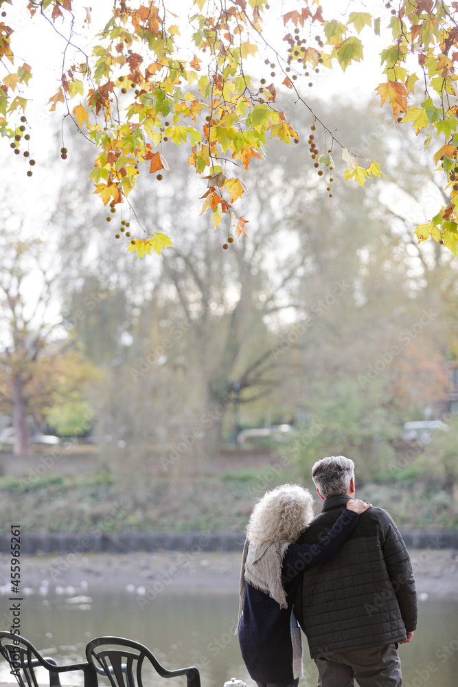 Affectionate active senior couple at autumn park pond Affectionate active senior couple at autumn park pond