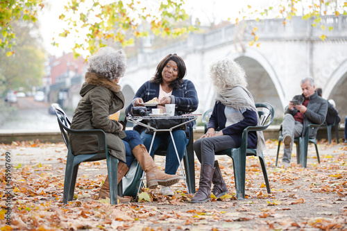 Portrait smiling, happy active senior women friends drinking coffee at autumn park cafe © KOTO