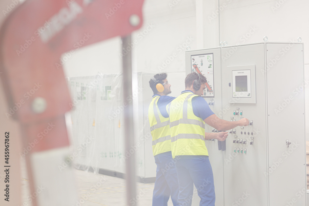 Engineers working at control panel in factory Engineers working at control panel in factory