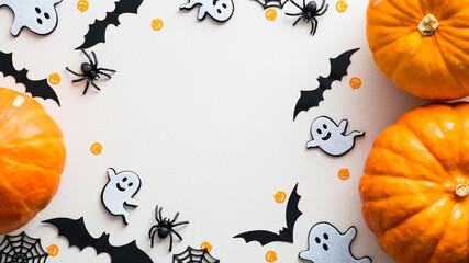 Cute halloween flat lay composition with pumpkins, ghosts, bats, spiders, web on white background. Flat lay, top view, copy space. Happy Halloween banner design.