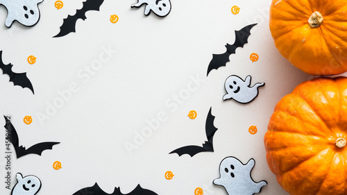 Halloween background with cute decorations and pumpkins on white table. Flat lay, top view, copy space. Halloween party invitation card mockup.