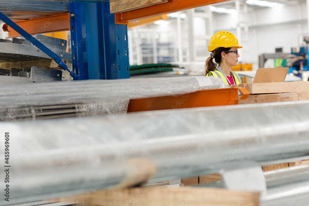 Female worker using laptop in factory Female worker using laptop in factory