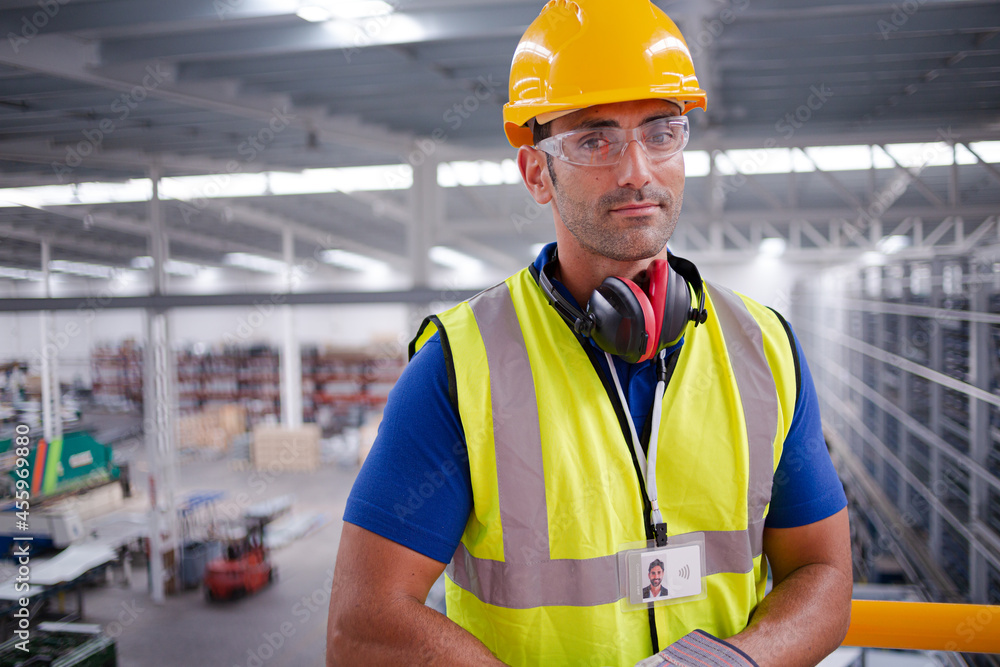 Portrait serious male worker in protective eyewear and hard-hat in factory Portrait serious male worker in protective eyewear and hard-hat in factory