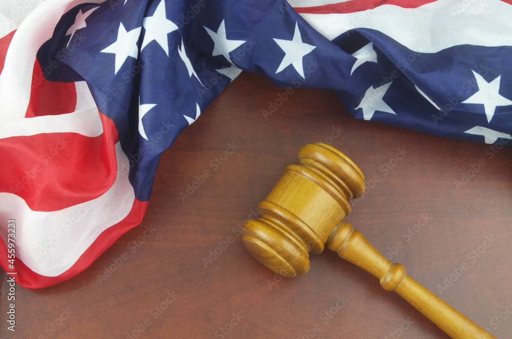 Wooden judge gavel and USA flag. Laws and court of US concept.	