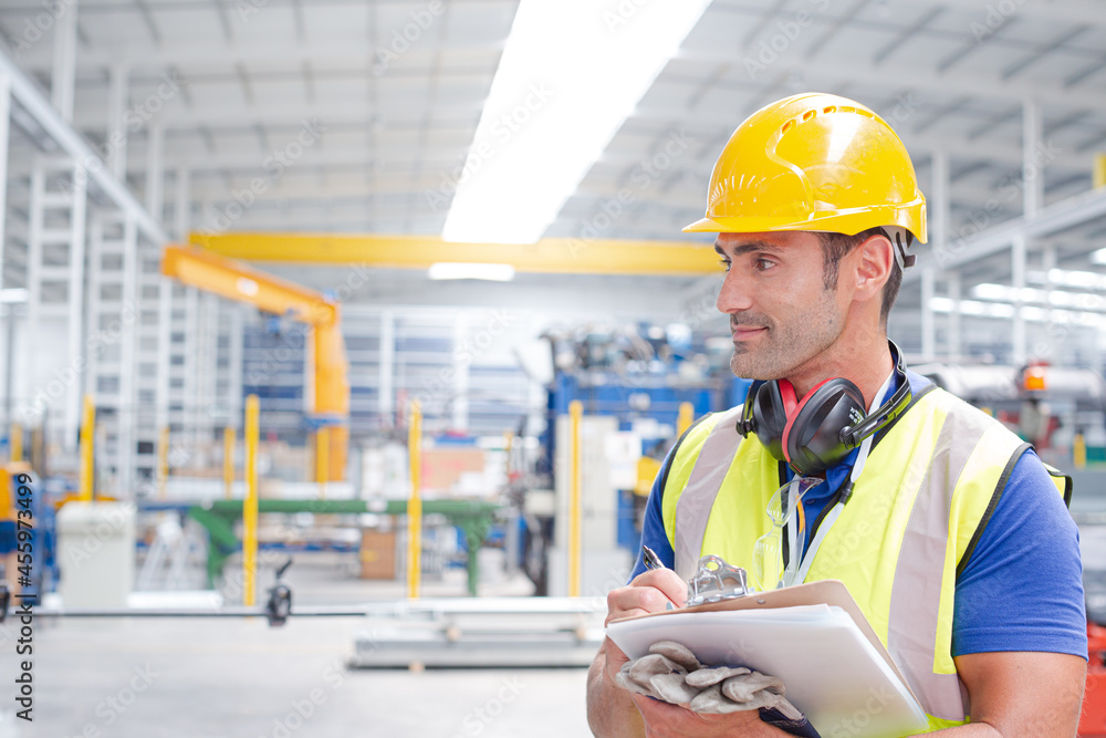Portrait confident worker with clipboard in steel factory Portrait confident worker with clipboard in steel factory
