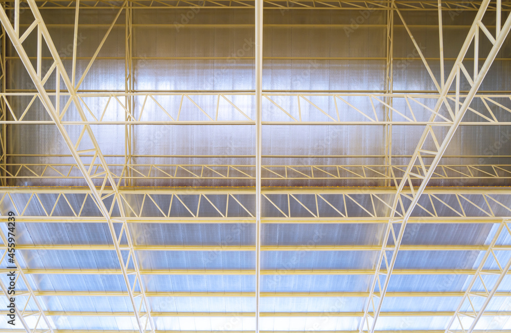 Low angle view of metal roof structure with heat insulations inside of industrial building construction site
