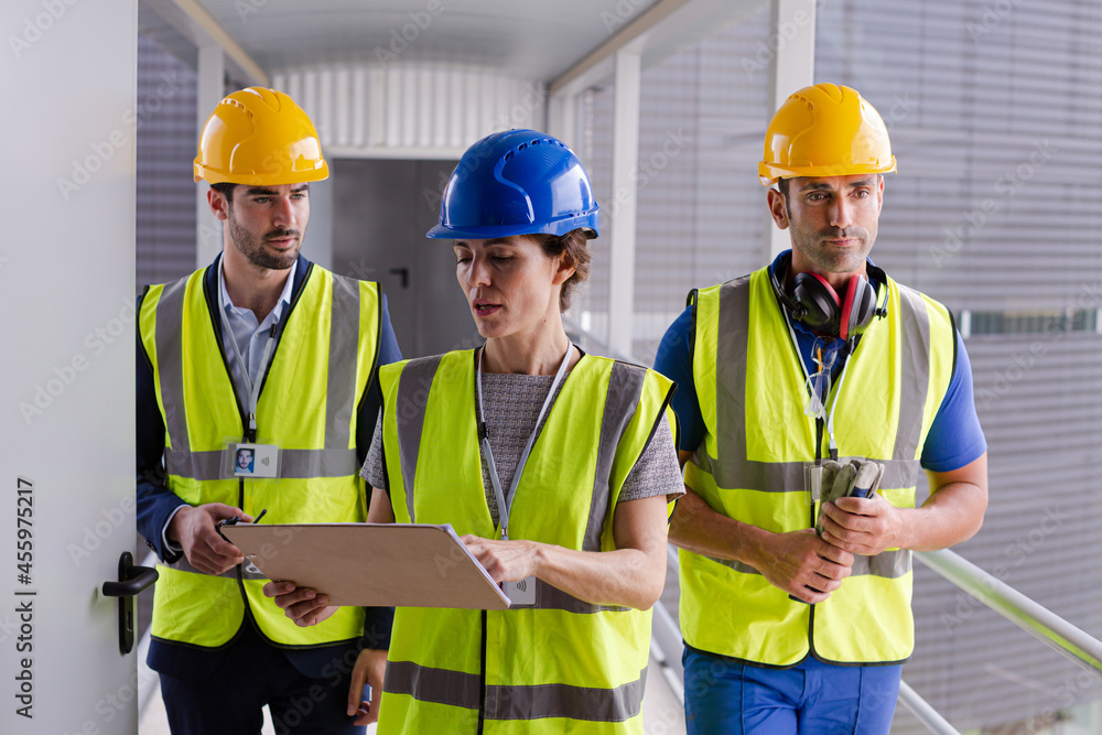 Supervisors and worker with clipboard in factory Supervisors and worker with clipboard in factory