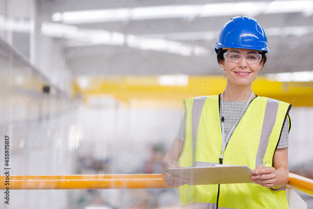 Portrait confident female supervisor with clipboard in steel factory Portrait confident female supervisor with clipboard in steel factory