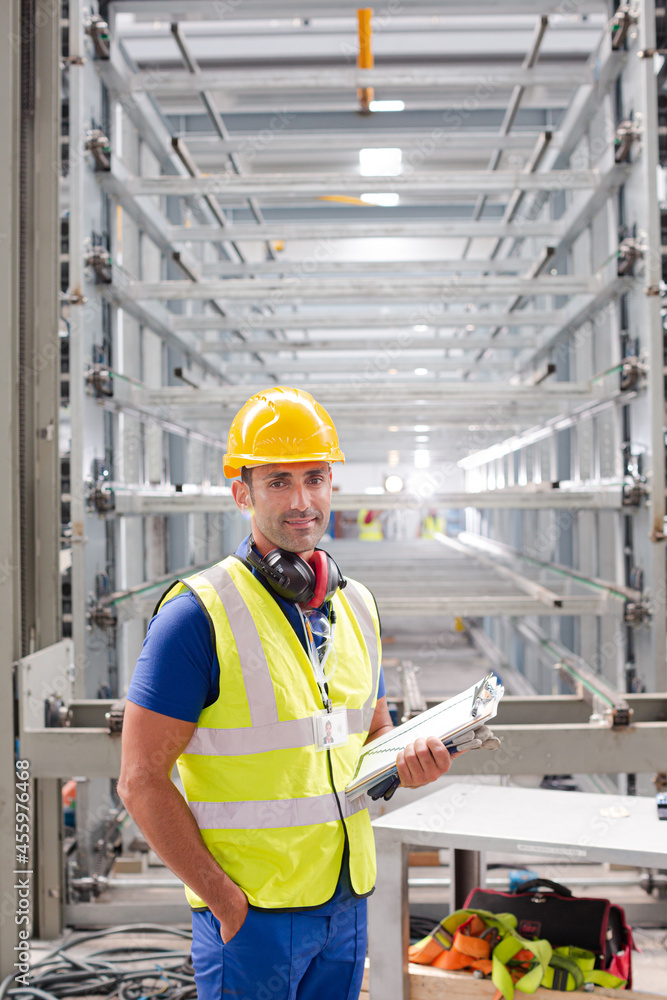 Portrait confident worker with clipboard in steel factory Portrait confident worker with clipboard in steel factory