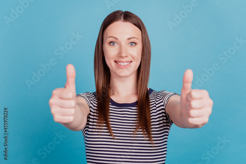Portrait of charming cheerful cute adorable lady raise thumb up reliable agreement on blue background © Tetiana