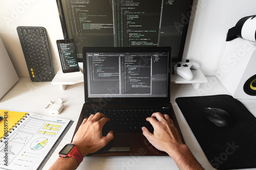 Close-up of male hands on the laptop at modern developer workplace for writing code.