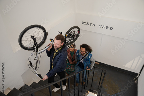 Photography Friends carrying bicycle up stairwell
