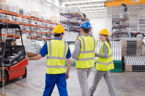 Supervisor and workers talking in warehouse © KOTO
