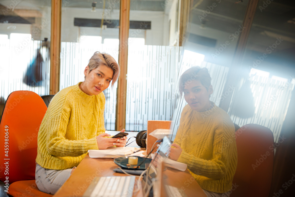 Obraz premium Portrait of young woman working at desk, smiling