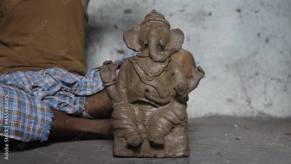 Artist removing Plaster of paris or Pop and placing or recommending Clay Ganesh idol for festival celebration. Artist removing Plaster of paris or Pop and placing or recommending Clay Ganesh idol for festival celebration.