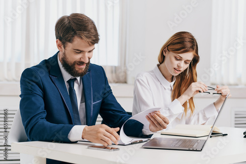 man and woman managers sitting at the table in front of laptop office technology