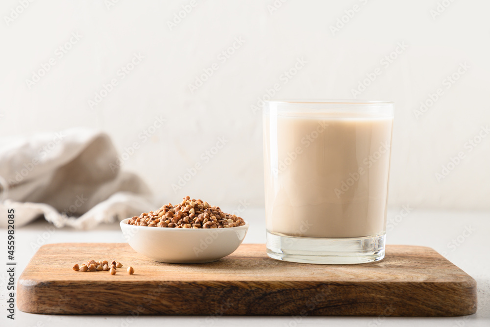 Buckwheat milk served in drinking glass with grain ingredient on a white background. Concept healthy lactose free and plant based vegan milk. Buckwheat milk served in drinking glass with grain ingredient on a white background. Concept healthy lactose free and plant based vegan milk.