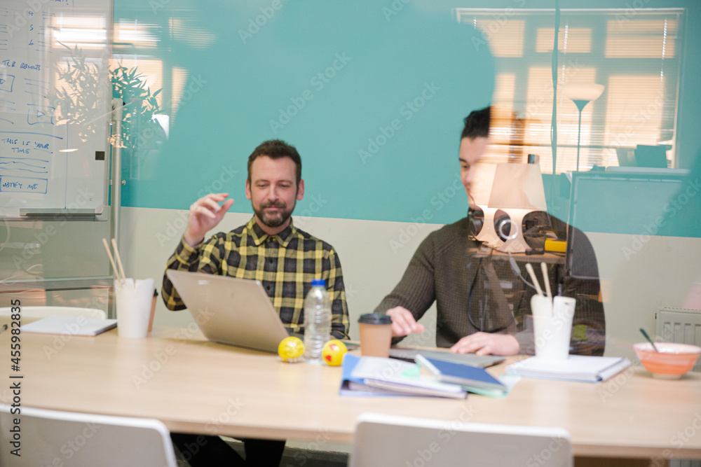 Colleagues working together at laptop in conference room Colleagues working together at laptop in conference room