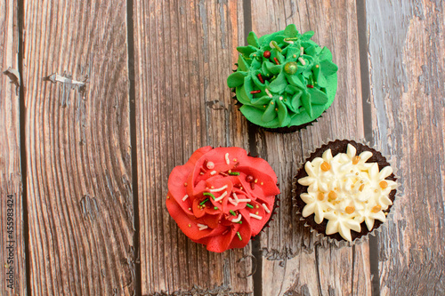Homemade colorful cupcakes on wooden table.