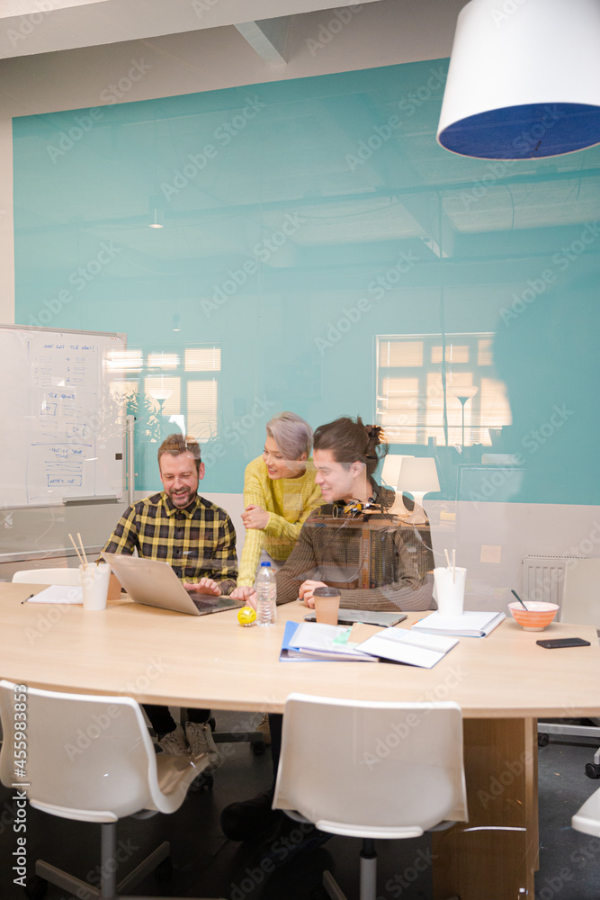 Obraz premium Three colleagues working at computer in conference room