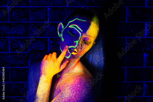 UV light woman with glowing lines and golden powder