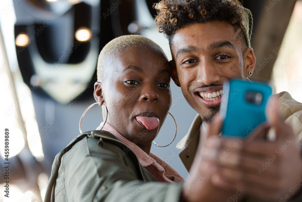 Obraz premium Smiling young couple taking selfie with camera phone
