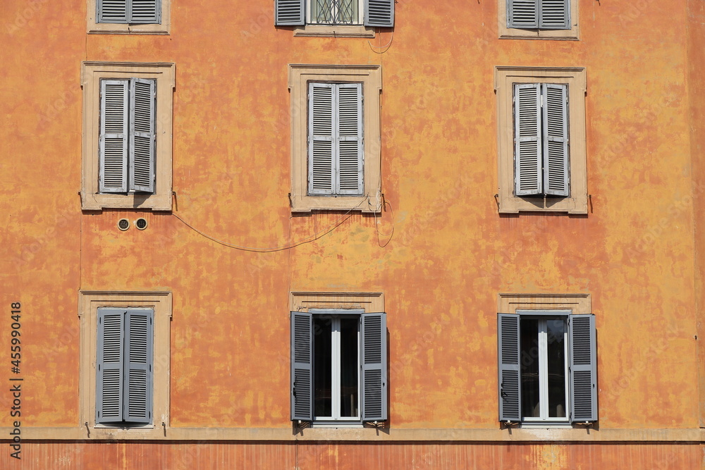 Colorful Warm Orange Brown Building Facade with Grey Shutters in Rome, Italy