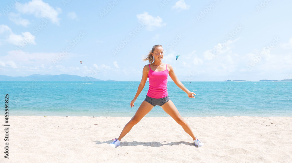 Fitness sport woman doing sporty exercise on beach outside at sunset. Healthy lifestyle image of beautiful young asian woman jogging on black sand beach.