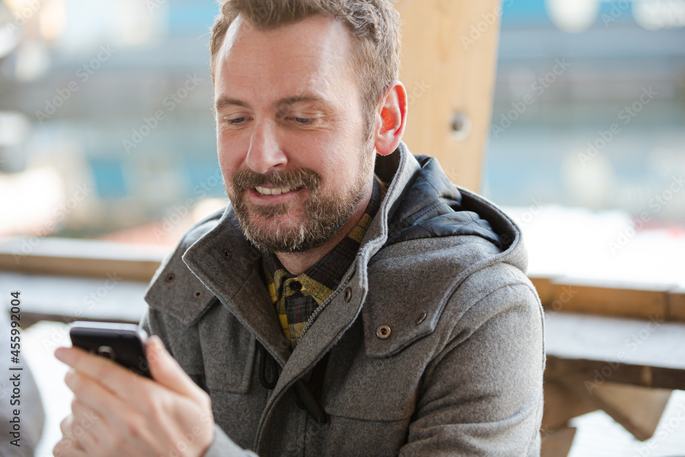 Portrait of smiling man using smartphone