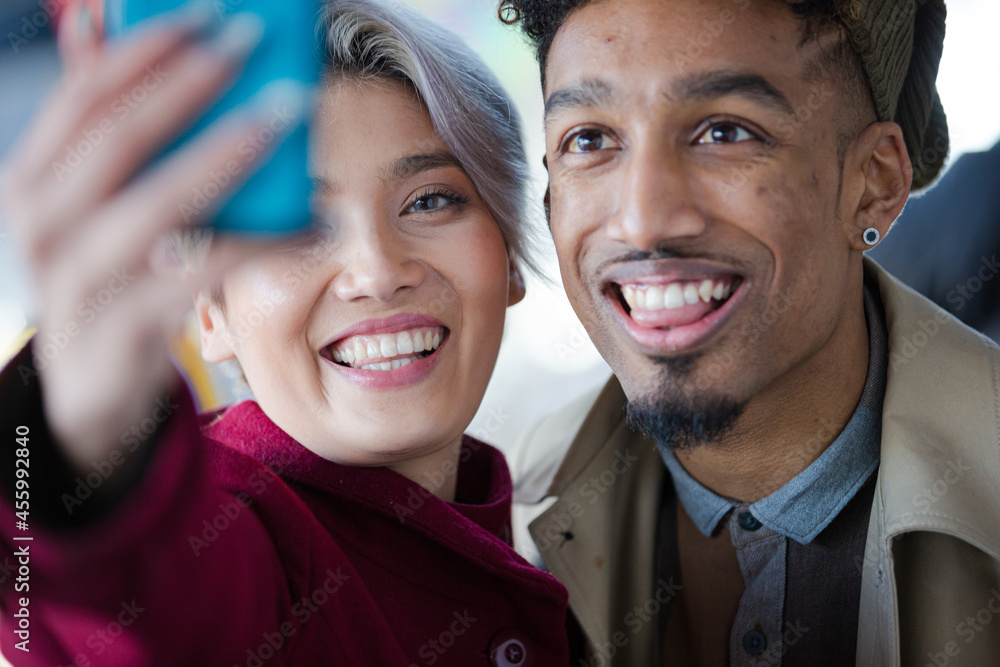 Smiling young couple taking selfie with camera phone