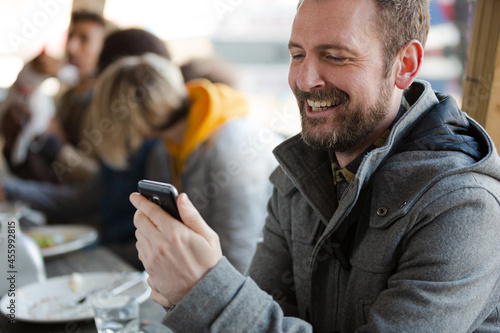 Man using smartphone while dining with friends