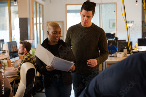 Man and woman discussing paperwork in office