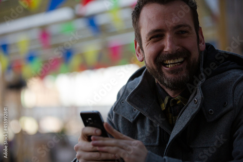 Portrait of smiling man using smartphone