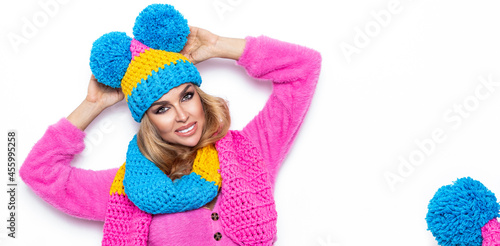 Image of happy young woman standing isolated over white background wearing warm scarf and beanie. Looking camera. Winter fashion.